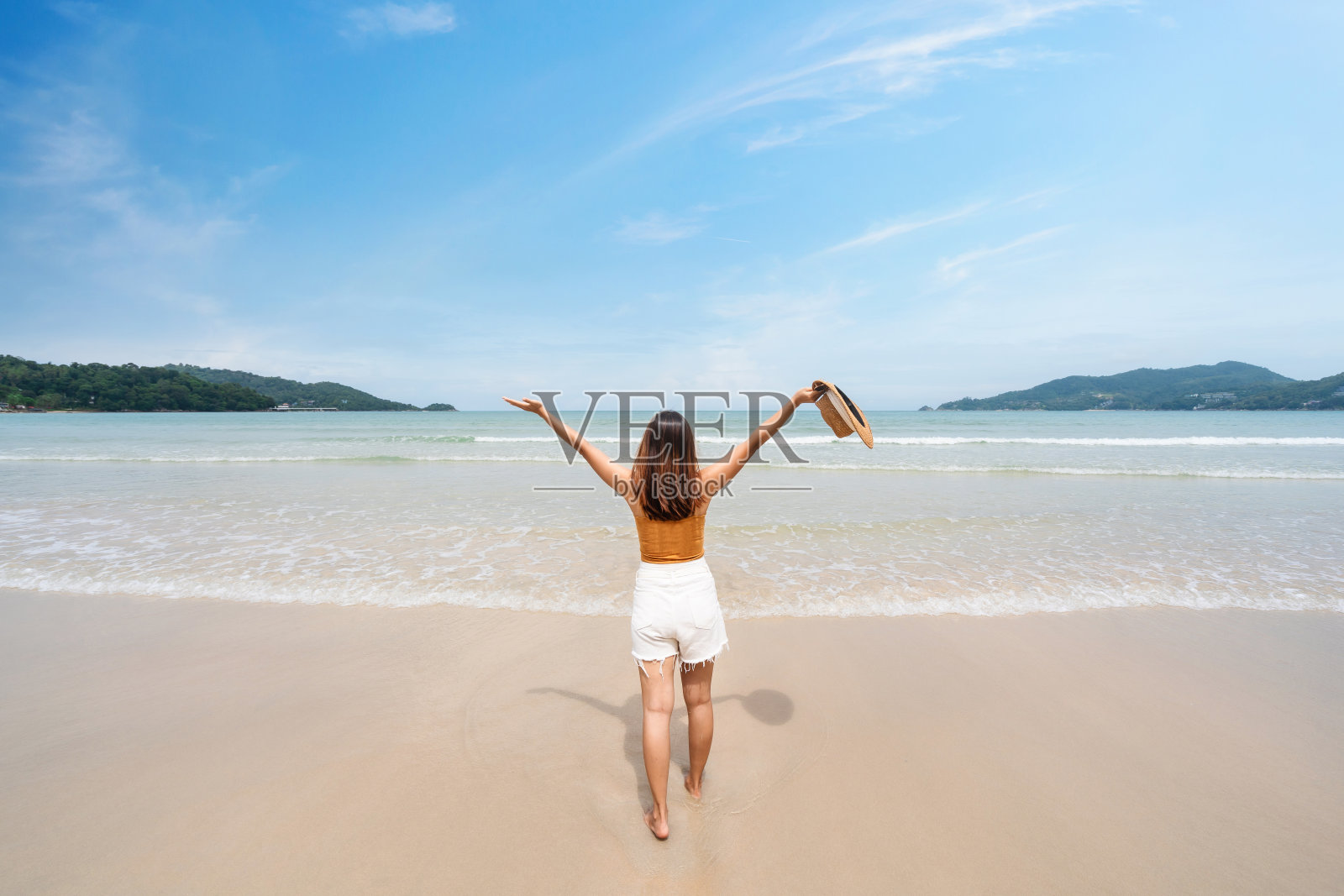 年轻女子旅行者放松和享受美丽的热带白色沙滩与海浪泡沫和透明的海，暑假和旅游概念照片摄影图片