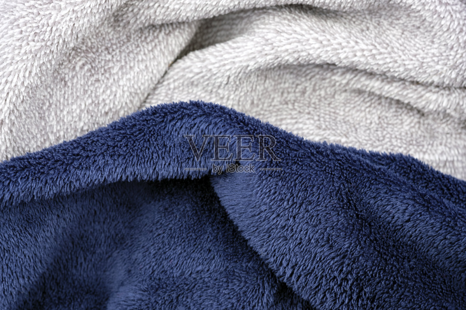 蓝色和灰色的绒毛，用来做装饰枕头的非自然织物。照片摄影图片