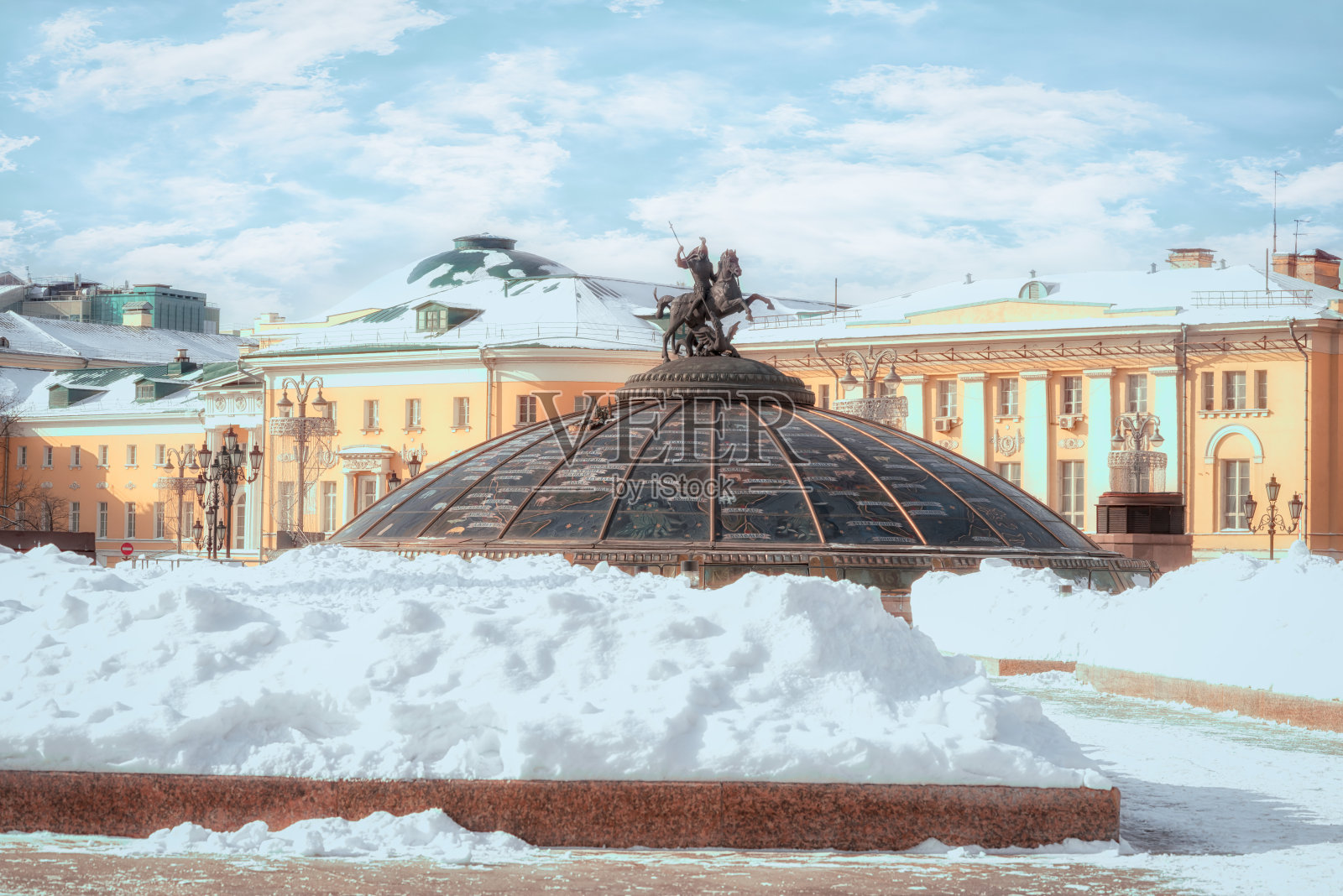 管理广场的雪堆。玻璃圆顶上有莫斯科的神圣守护神圣乔治的雕像。(俄文:世界著名城市的名字)。俄罗斯莫斯科的冬天。照片摄影图片