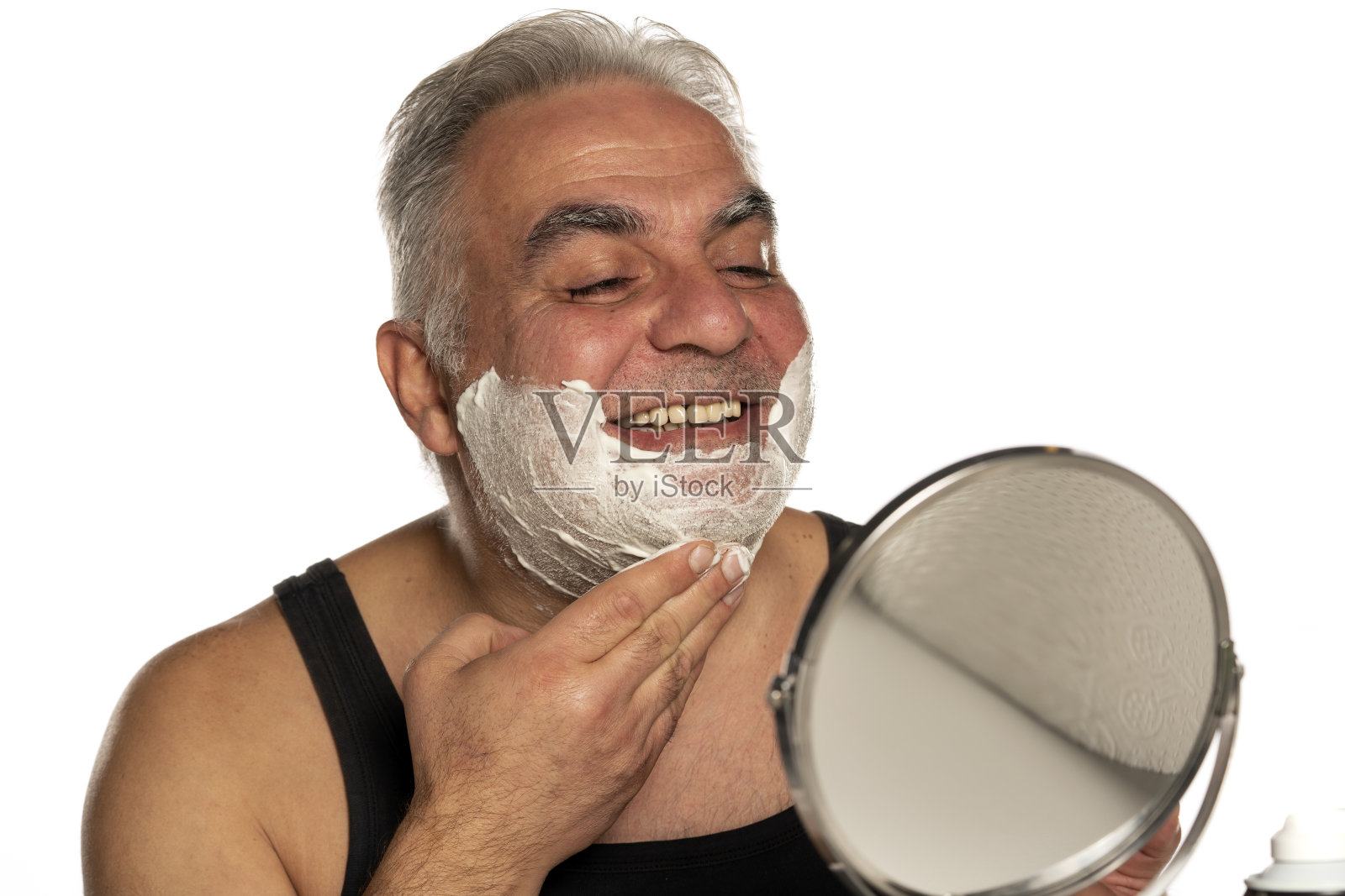 快乐的中年男子与短灰色头发应用剃须泡沫照片摄影图片