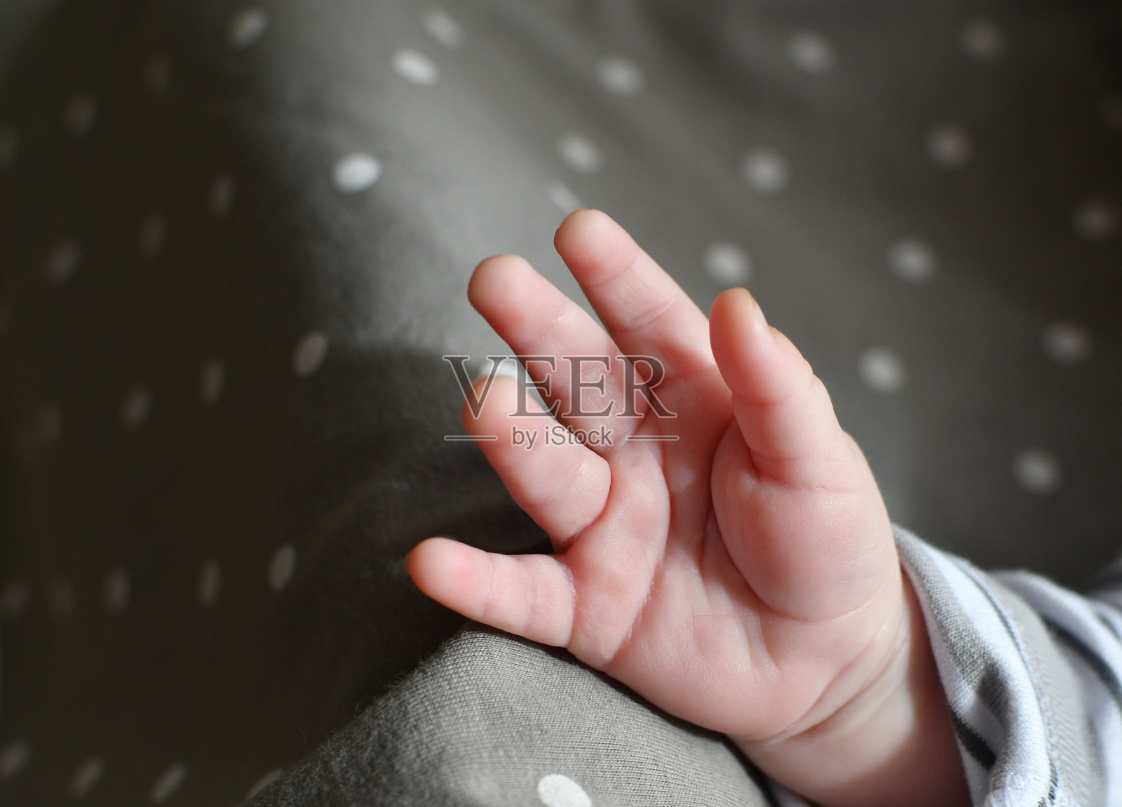 婴儿的手在黑暗的背景。小小的婴儿，孩子的手掌。有选择性的重点照片摄影图片