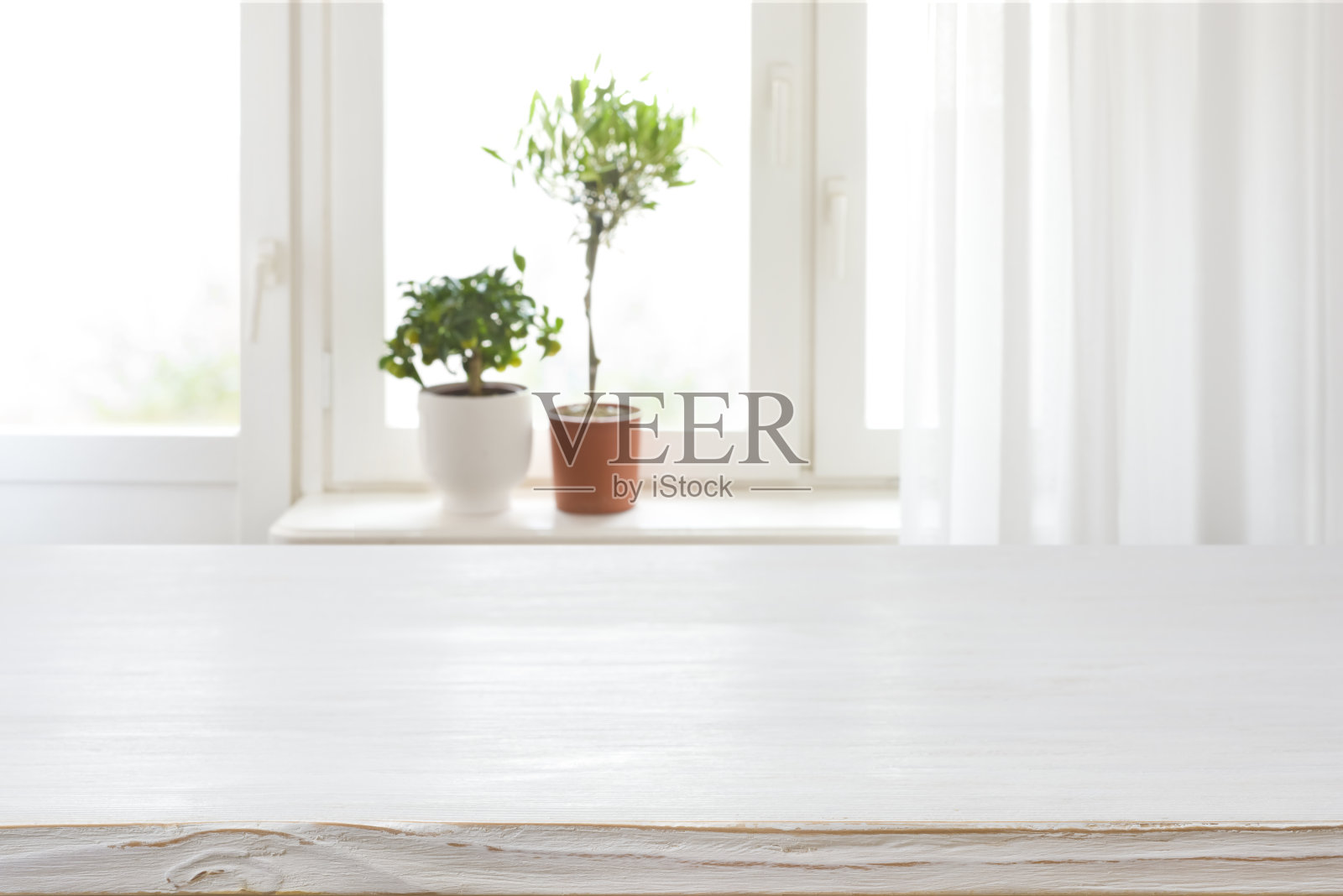 模糊窗台上的木纹桌子与室内植物背景照片摄影图片