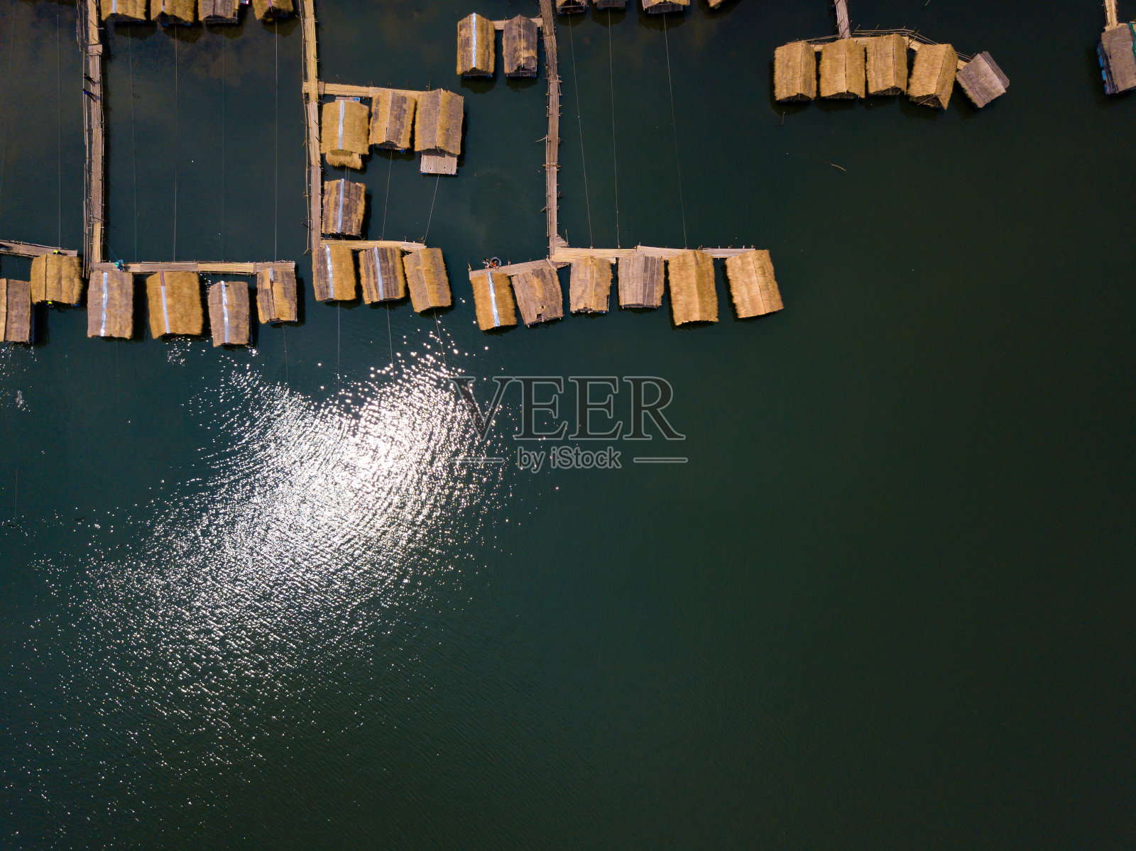 湖面上竹筏村舍，阳光倒映水面照片摄影图片