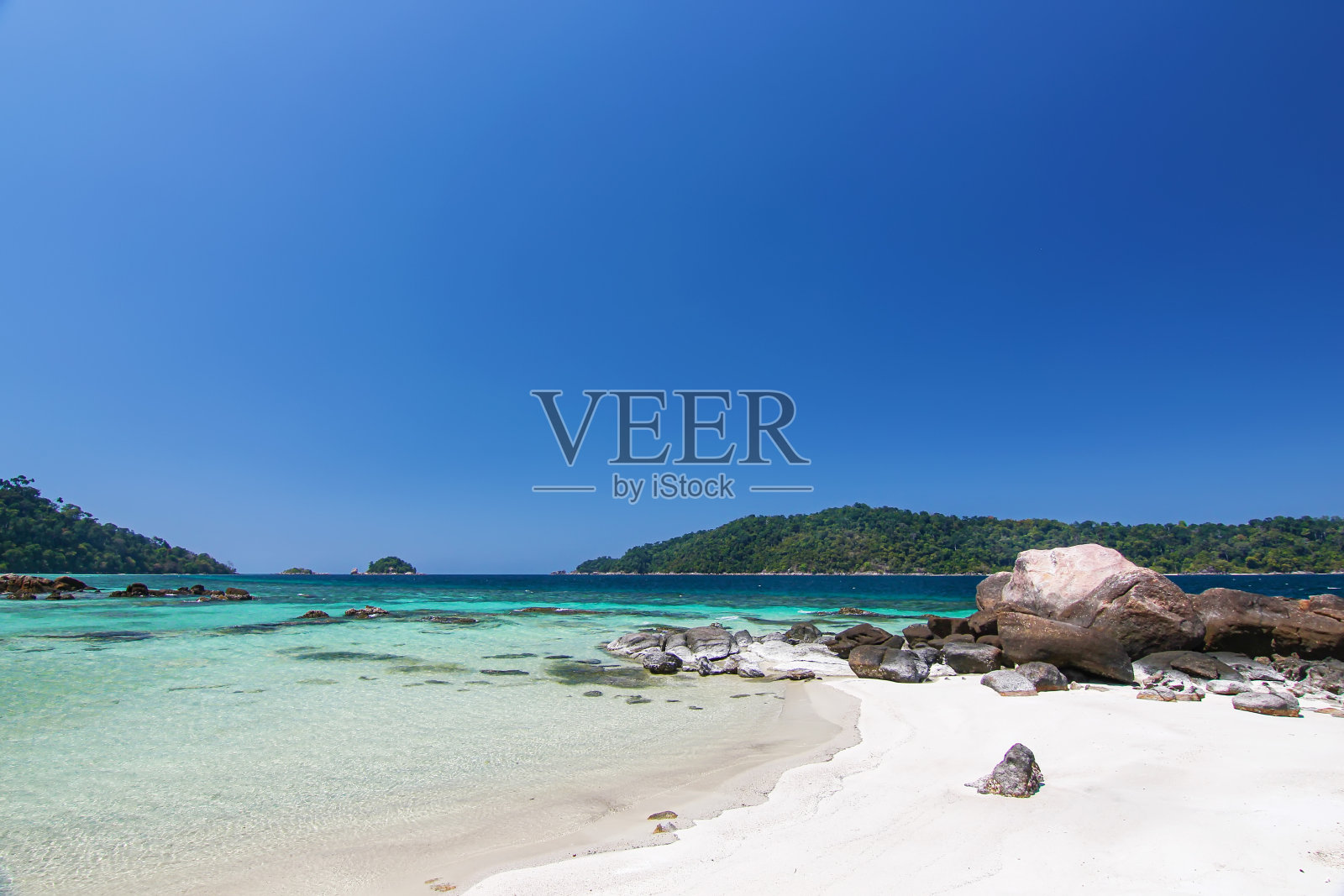 泰国旅游岛“Koh Lipe”绿松石海颜色的白色沙滩和石头海岸与阳光明媚的蓝天背景景观照片摄影图片