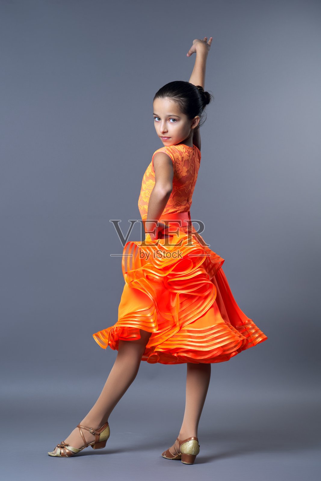 孩子体育舞蹈，孩子女孩在橙色运动服装摆姿势照片摄影图片