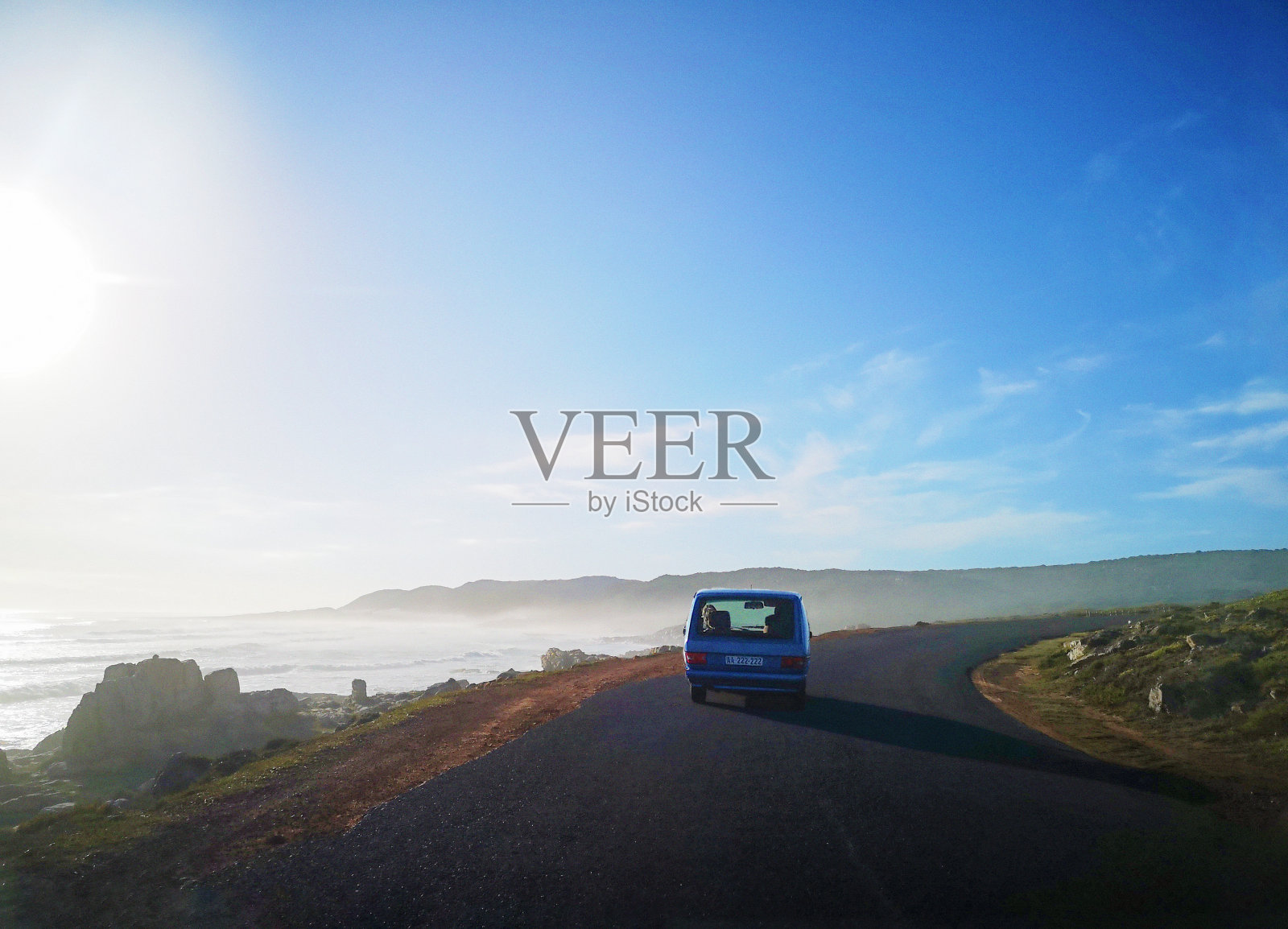 日落时分，汽车沿着南非南部的海岸线行驶照片摄影图片