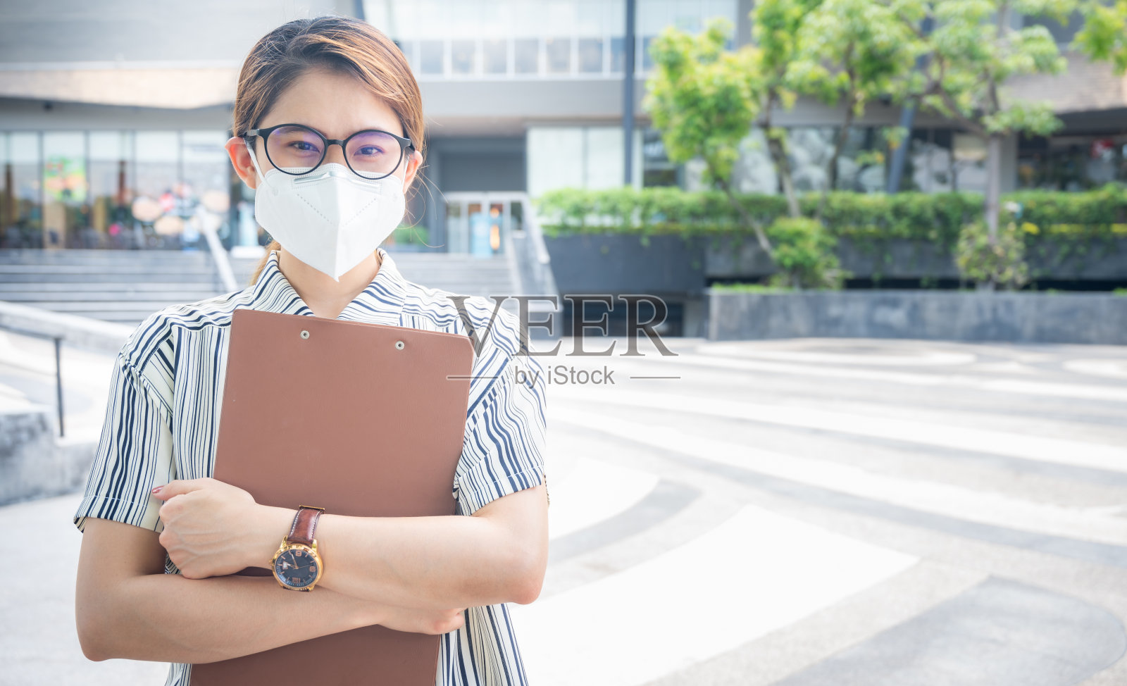 亚洲自信的女商人站在办公室外戴口罩，以保护自己免受covid-19病毒或严重污染。照片摄影图片