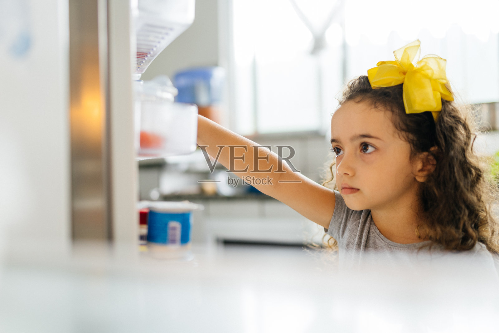 从冰箱里拿食物的女孩照片摄影图片