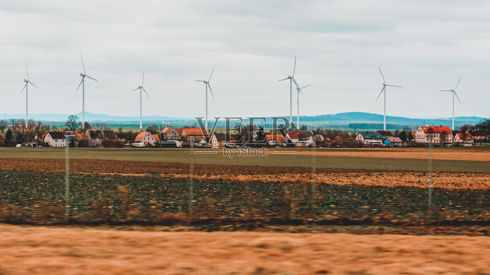 从车窗望向远方的波兰乡村的风车照片摄影图片