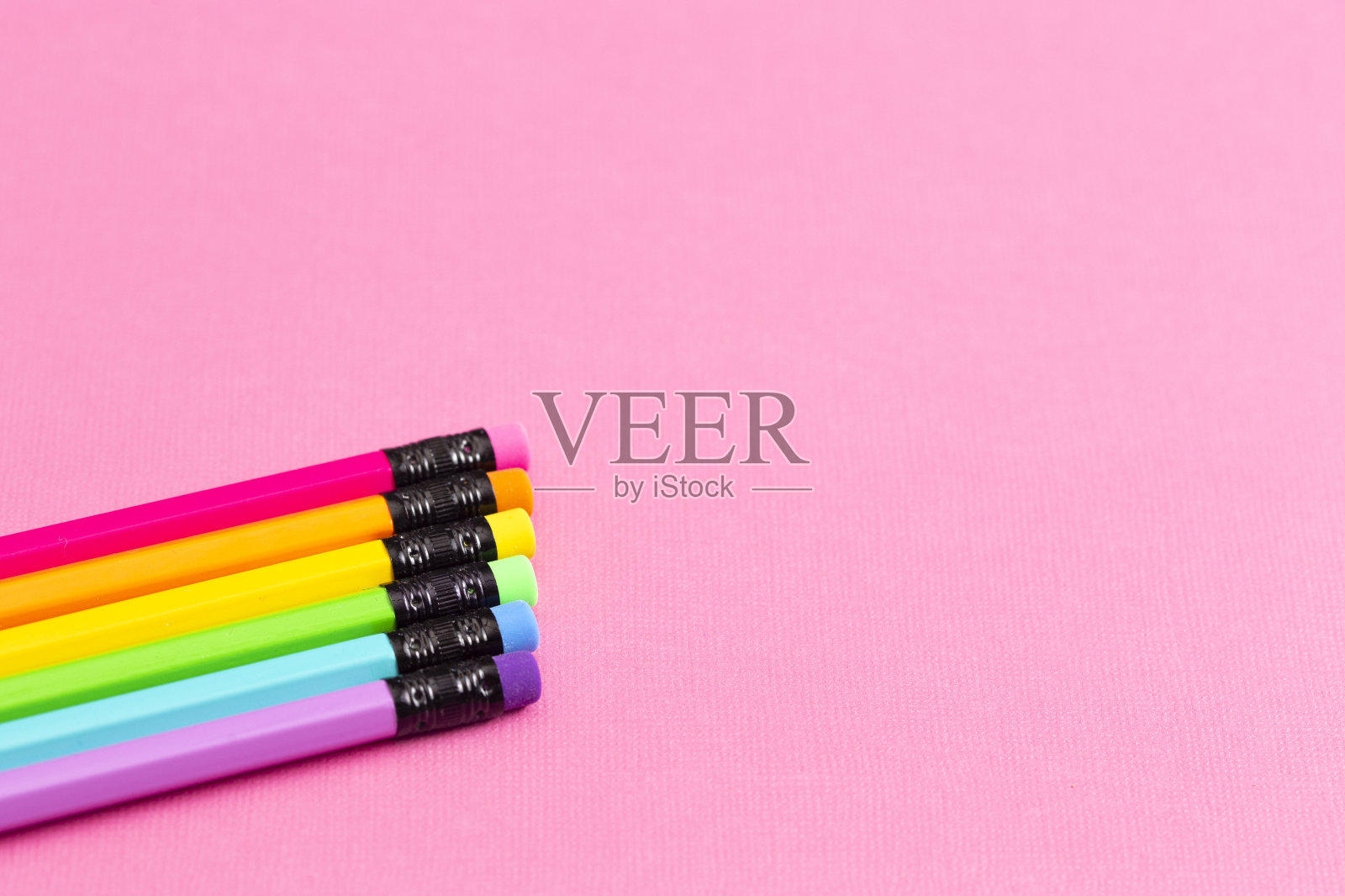 明亮的粉红色桌子上有彩虹铅笔的背景非常适合回到学校照片摄影图片
