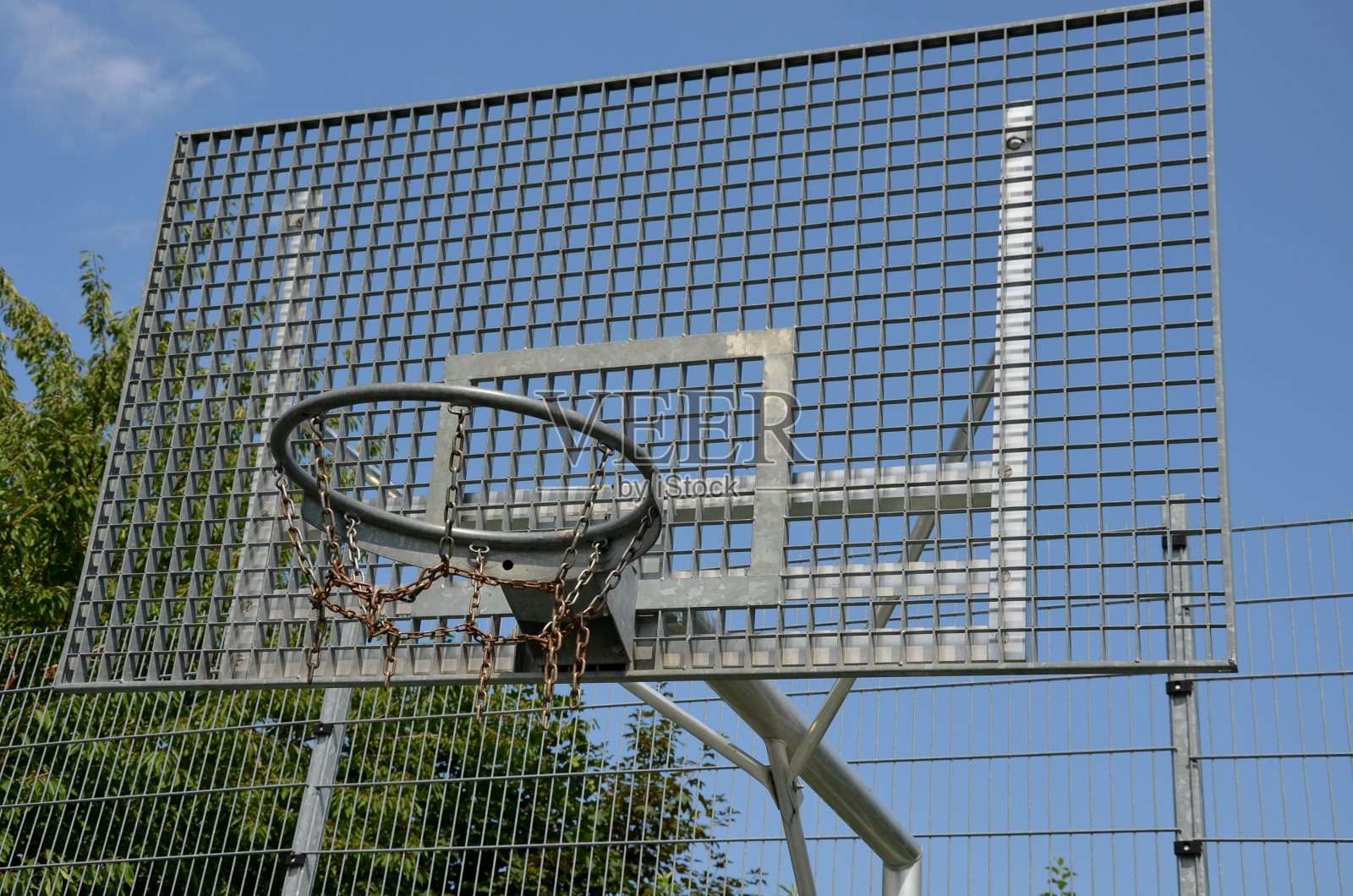 学校的多功能户外球类运动场地。绿色人造草皮从塑料地毯与线条。篮球圈和足球球门。在高高的网和护栏周围照片摄影图片