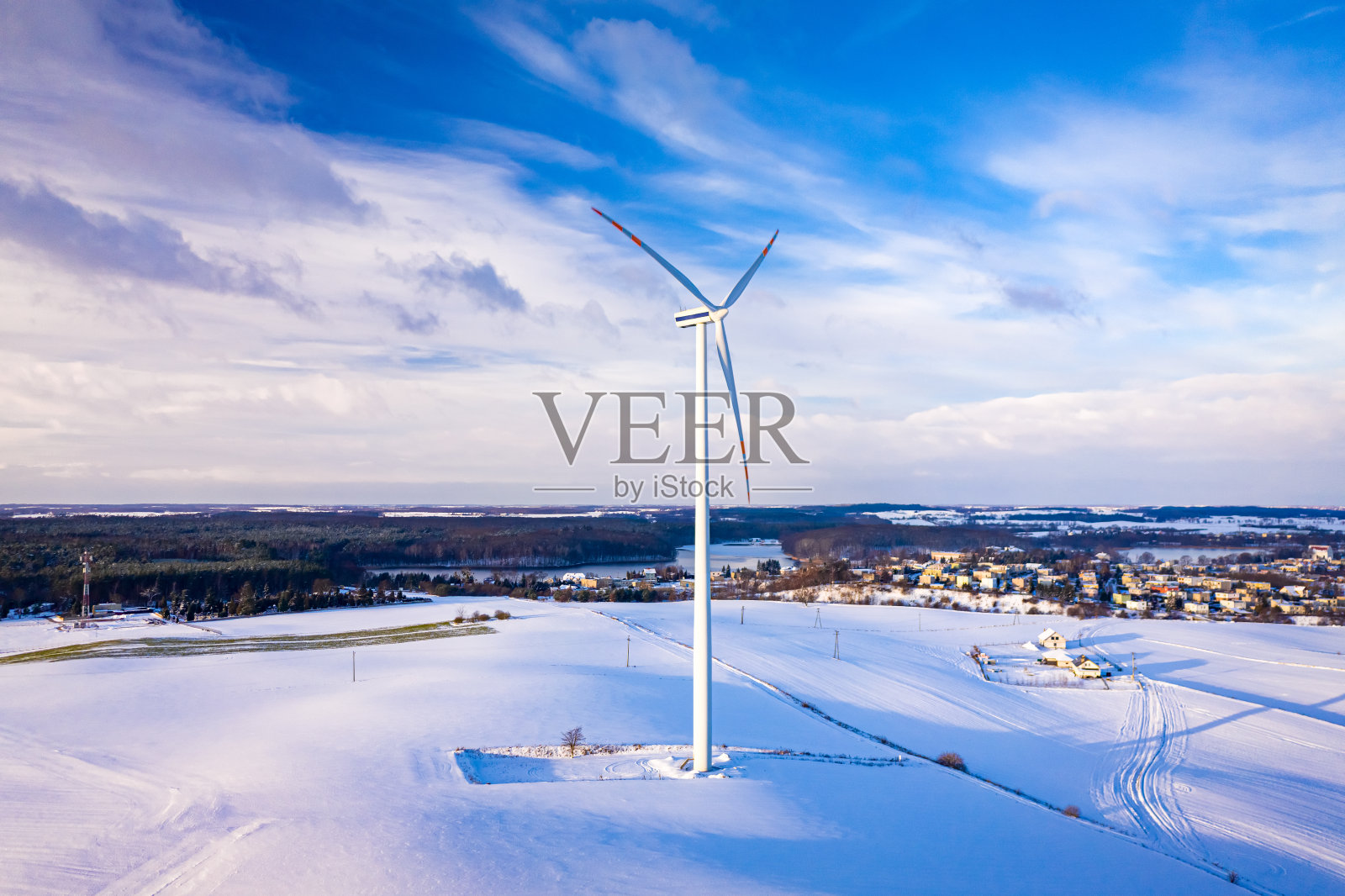 冬季日出时雪域上的风力发电机。照片摄影图片