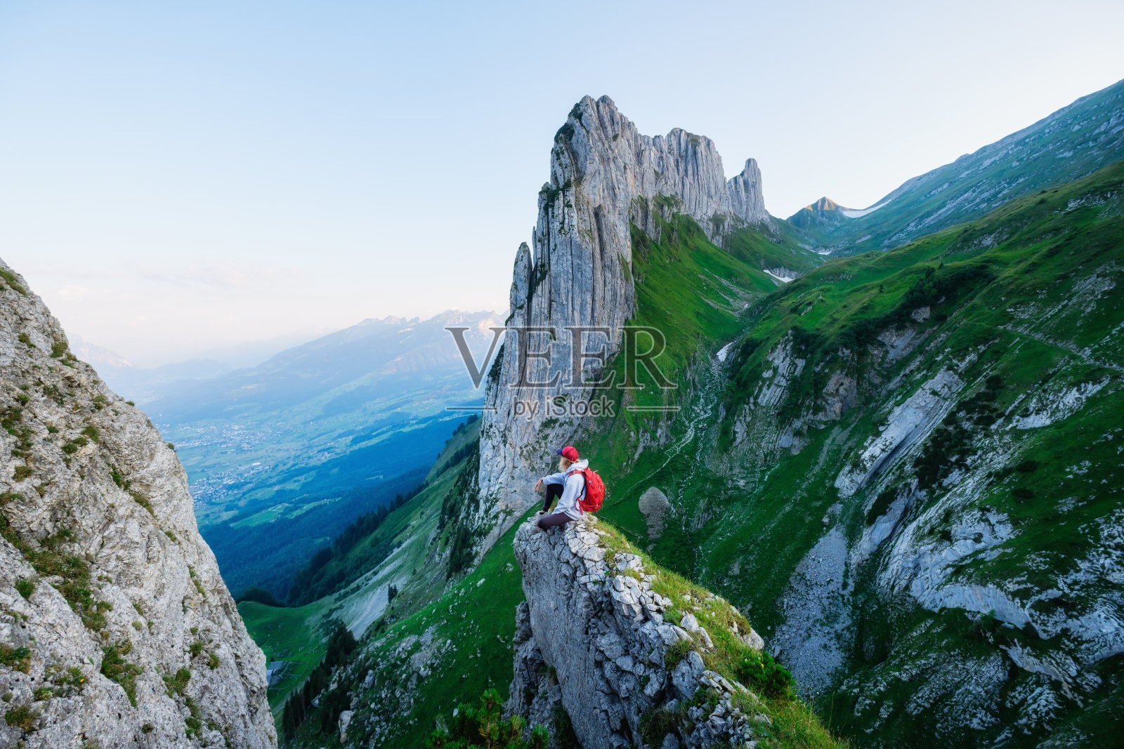 游客在高高的岩石背景上。运动与积极生活理念。在瑞士山区的冒险和旅行。照片摄影图片