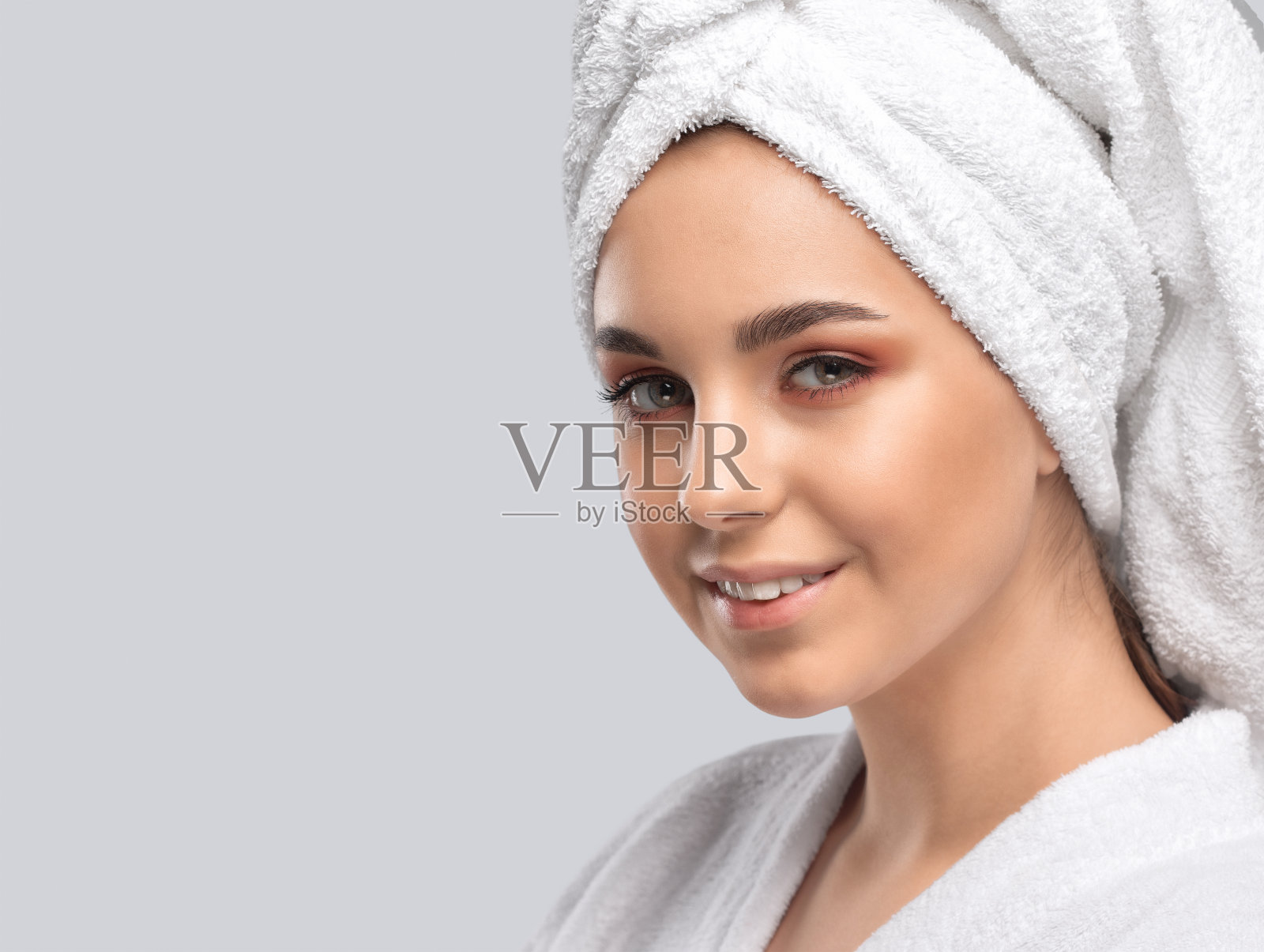 一个美丽的黑发女孩的肖像穿着白色的外套，健康干净的皮肤和新鲜的化妆。美学美容和化妆概念。照片摄影图片