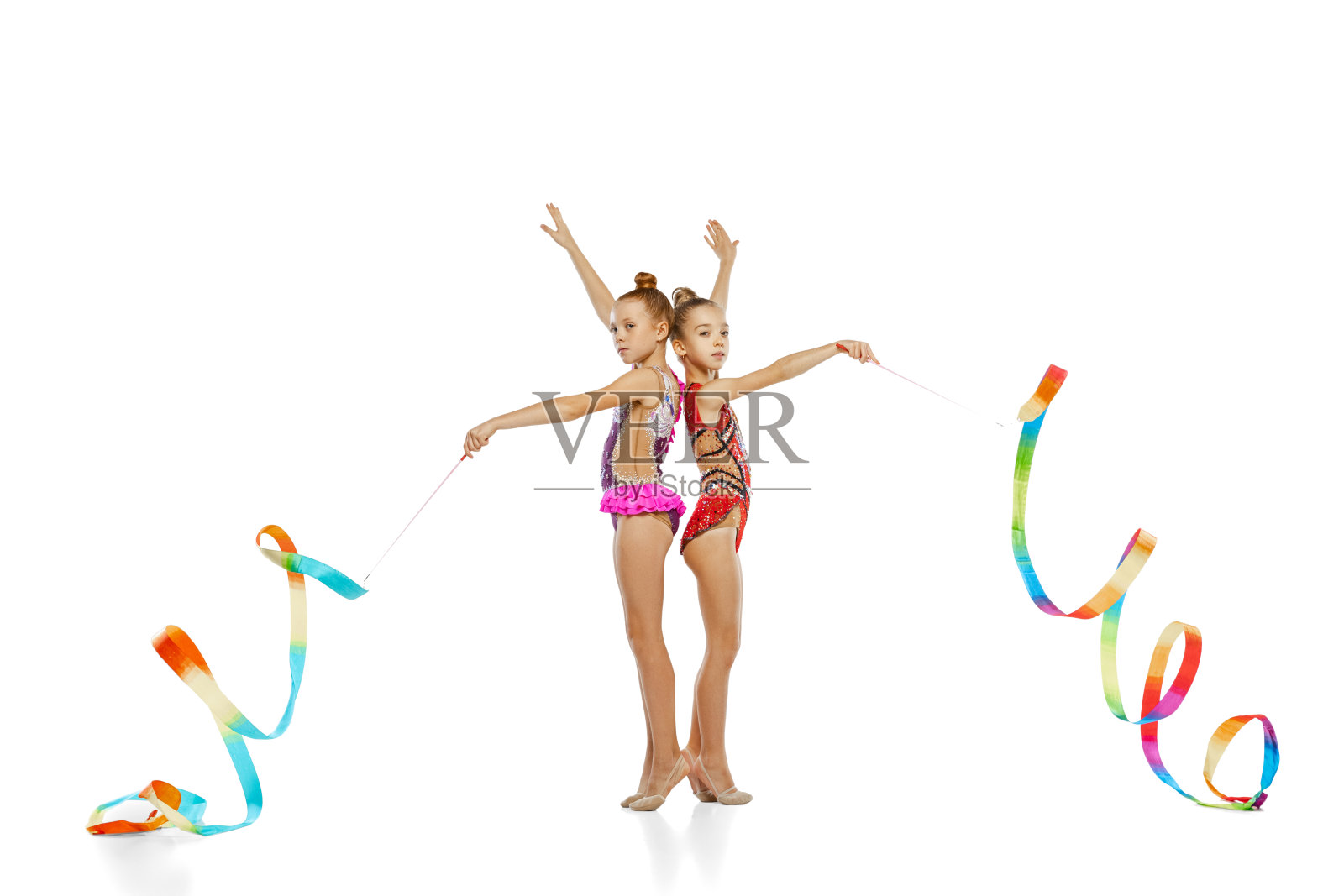 Two-ribbon事件。小美丽的艺术体操艺术家的肖像在团体运动事件孤立在白色工作室背景。照片摄影图片