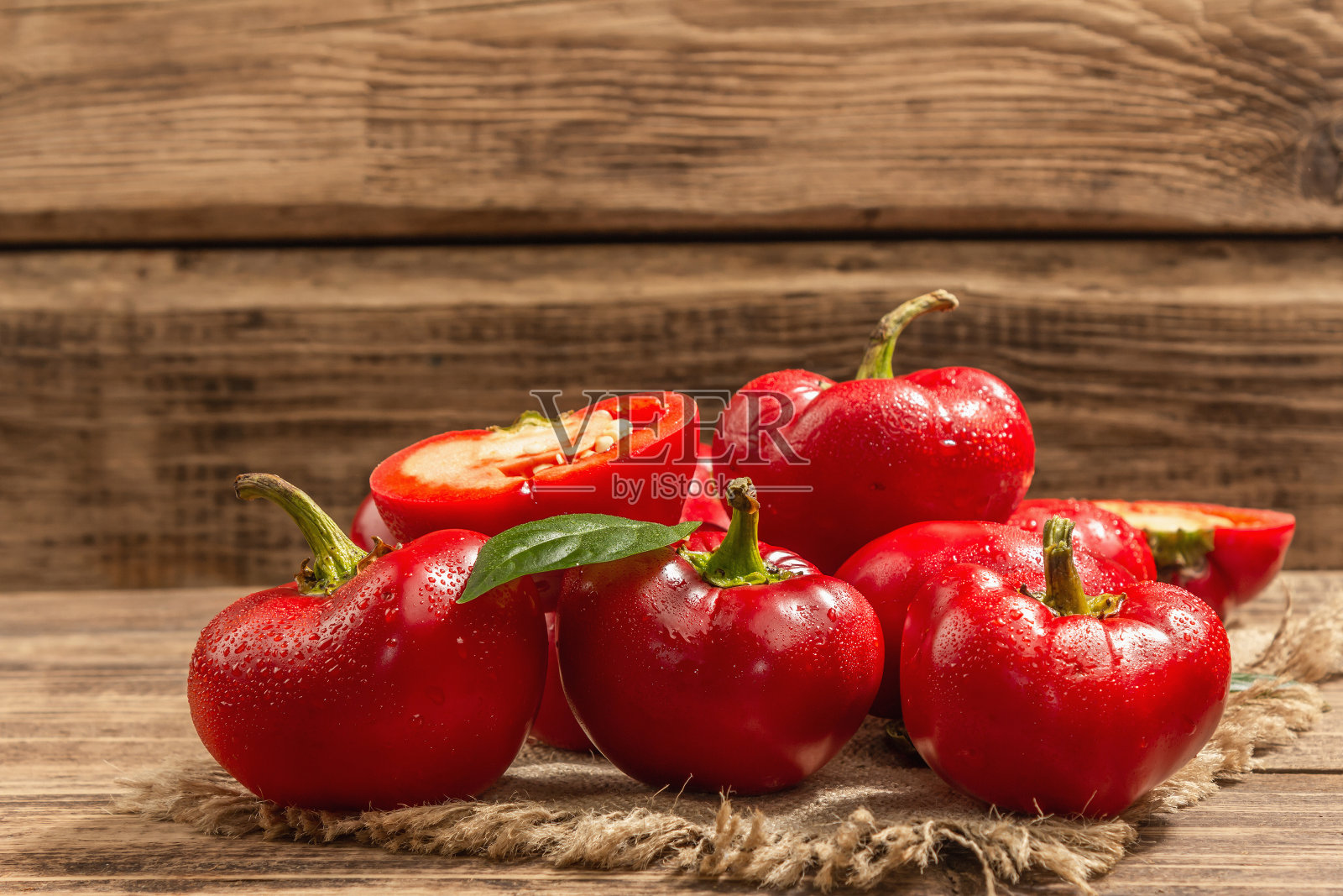 在手工制作的柳条篮子里装着成熟的红圆辣椒。新鲜蔬菜，烹饪健康食品的原料照片摄影图片