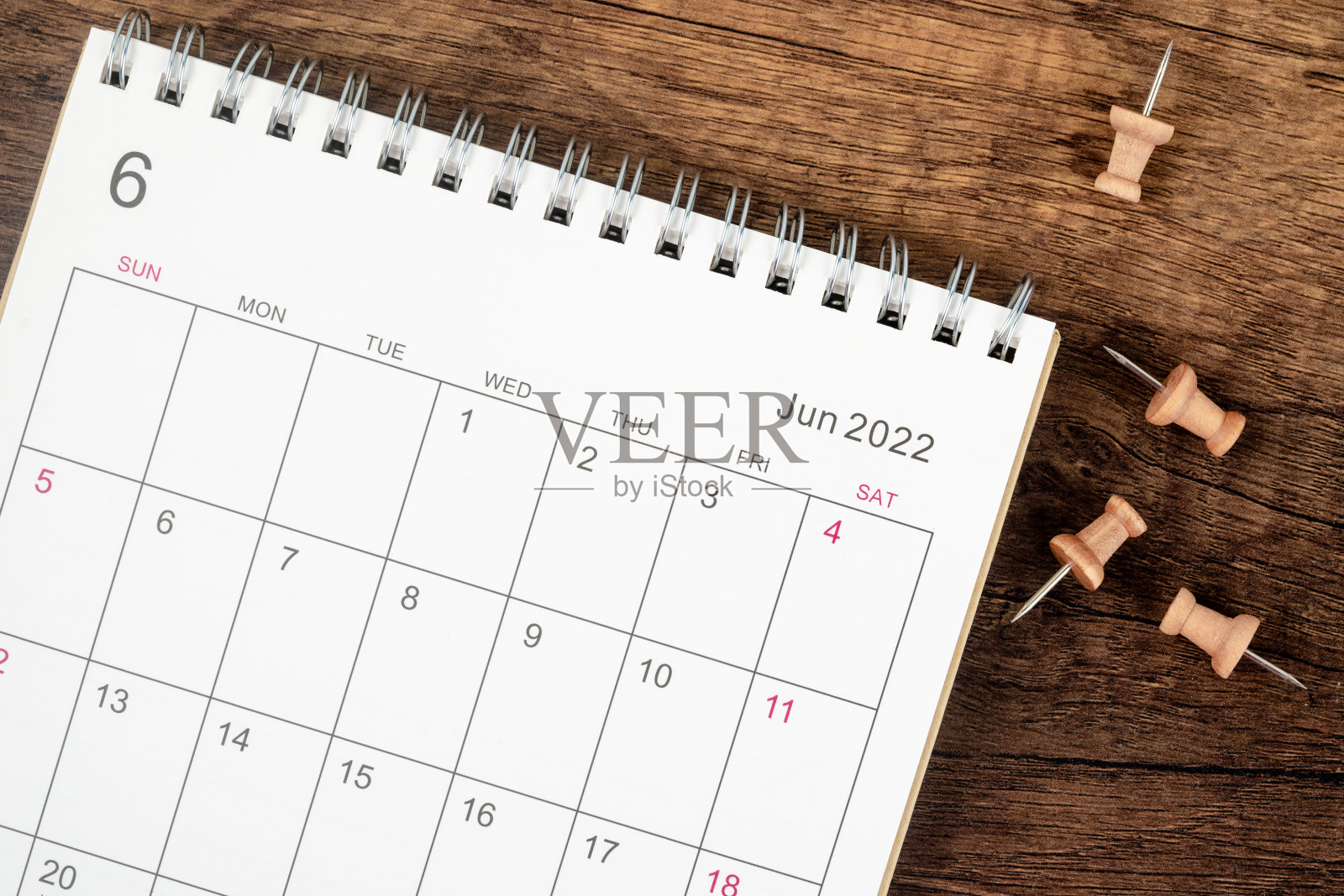 俯视图日历桌2022年6月月，规划的概念和期限与木桌背景上的推针。照片摄影图片