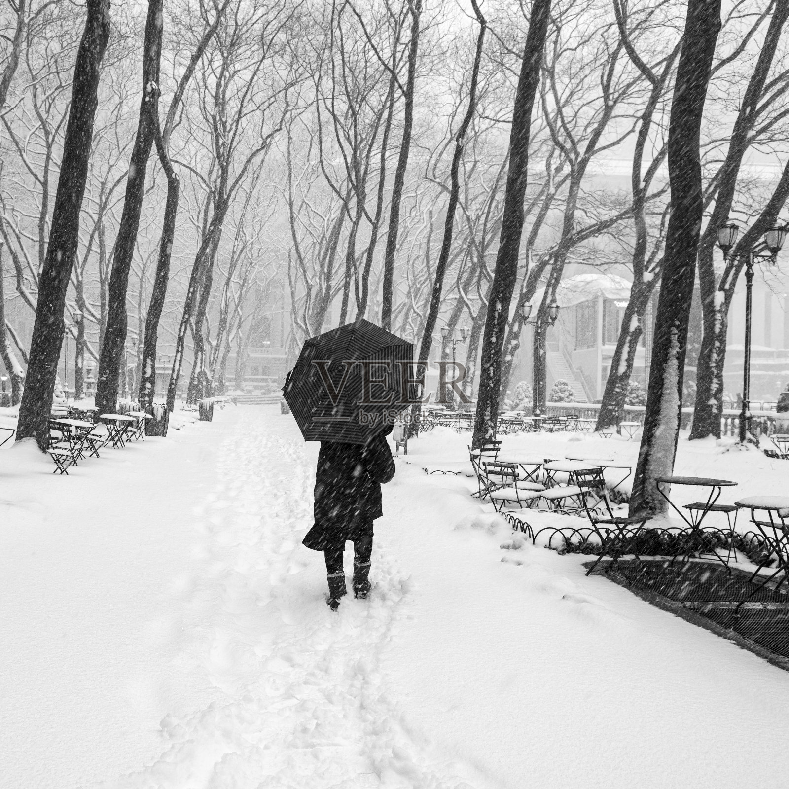 行人走在曼哈顿中城布赖恩特公园白雪覆盖的街道上照片摄影图片
