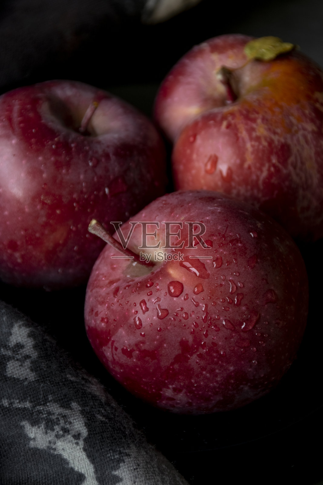 靠近三个红苹果。暗情绪食品摄影照片摄影图片