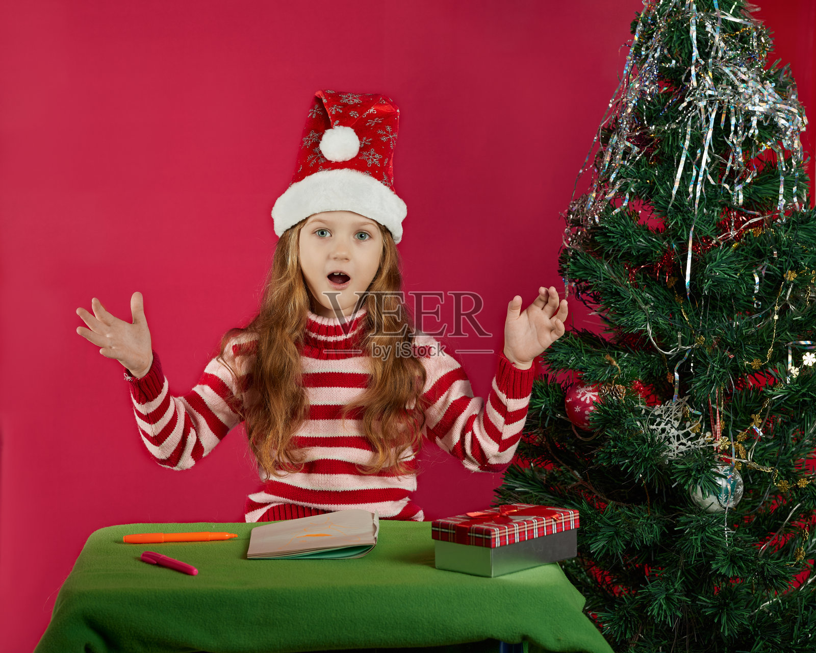 圣诞节，假日和童年概念-微笑的女孩制作愿望清单或写信给圣诞老人在家照片摄影图片