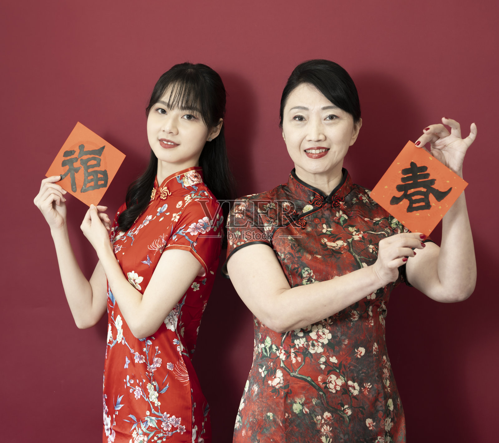 两个快乐的亚洲妇女女儿和母亲展示春联庆祝中国新年，中文文本:好运，中文文本:春天。照片摄影图片