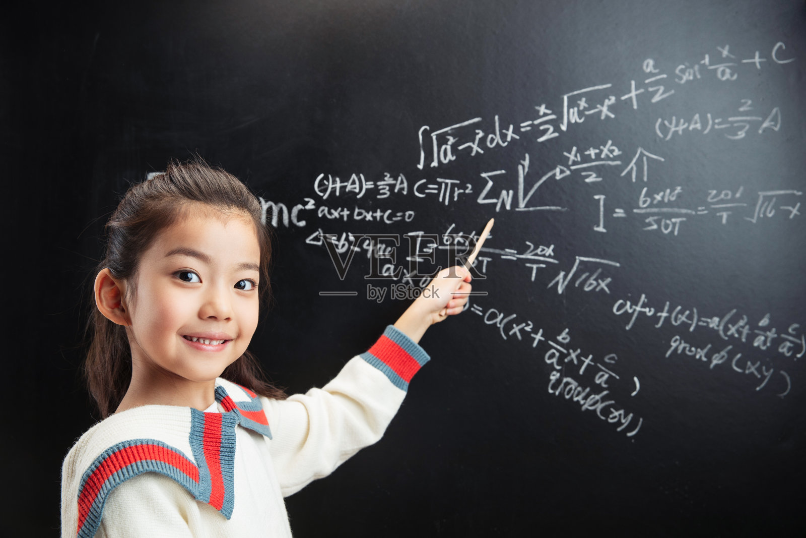 小女孩指着黑板上的数学题照片摄影图片