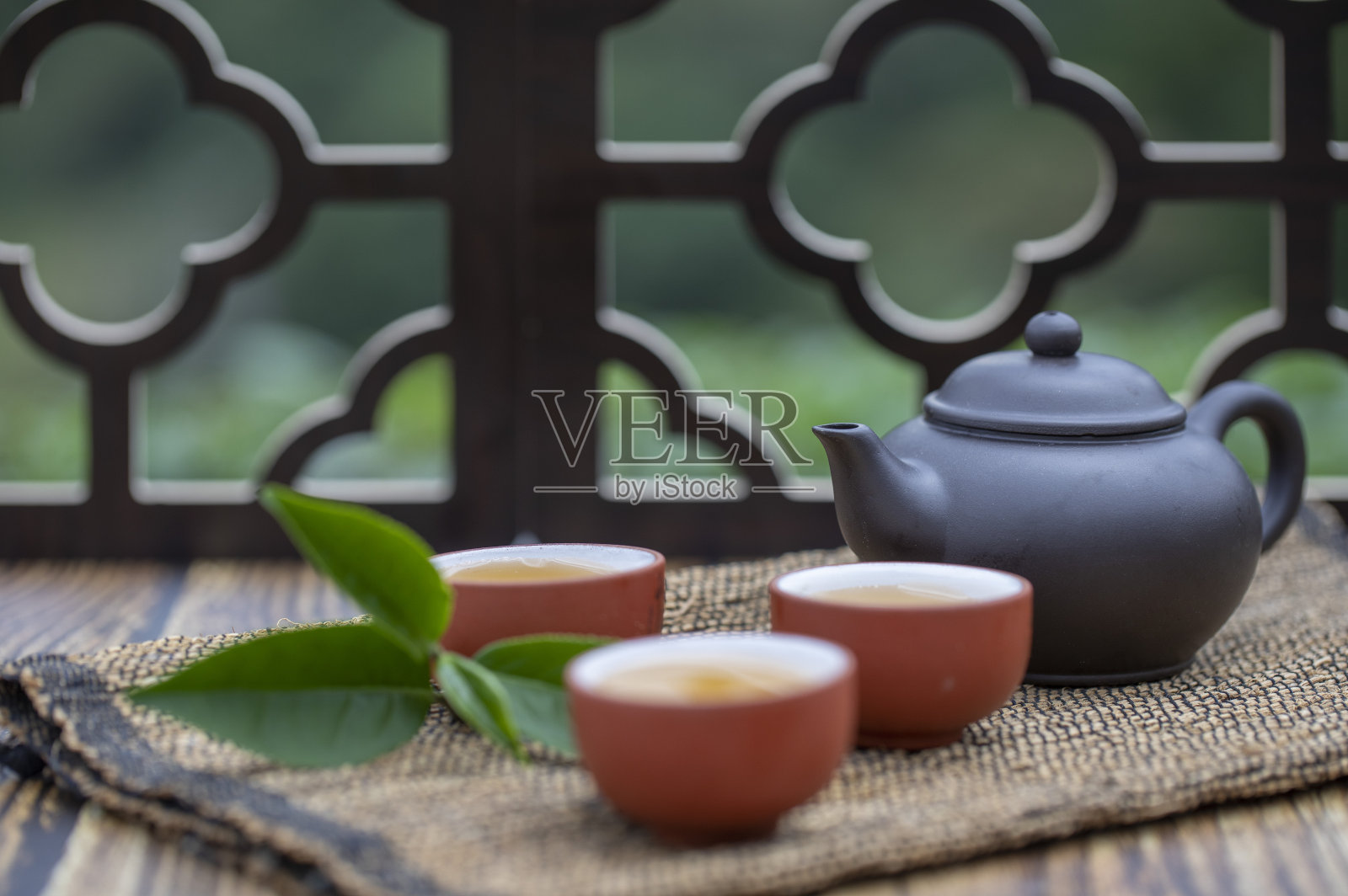 月光下窗花旁桌上的中国茶壶和茶杯富有禅意照片摄影图片