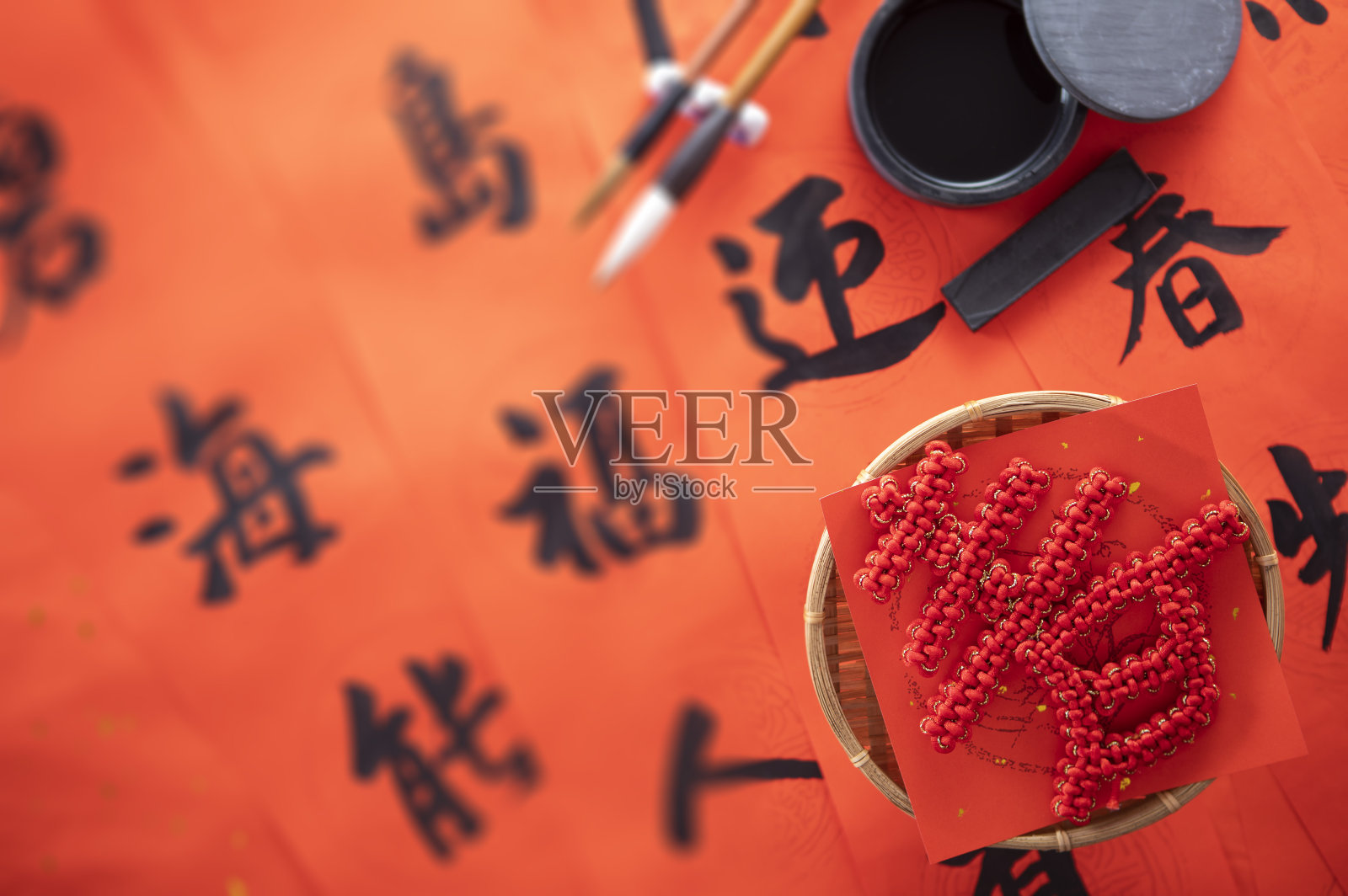 ,中国春节春联上摆放着春字中国结和毛笔砚台照片摄影图片