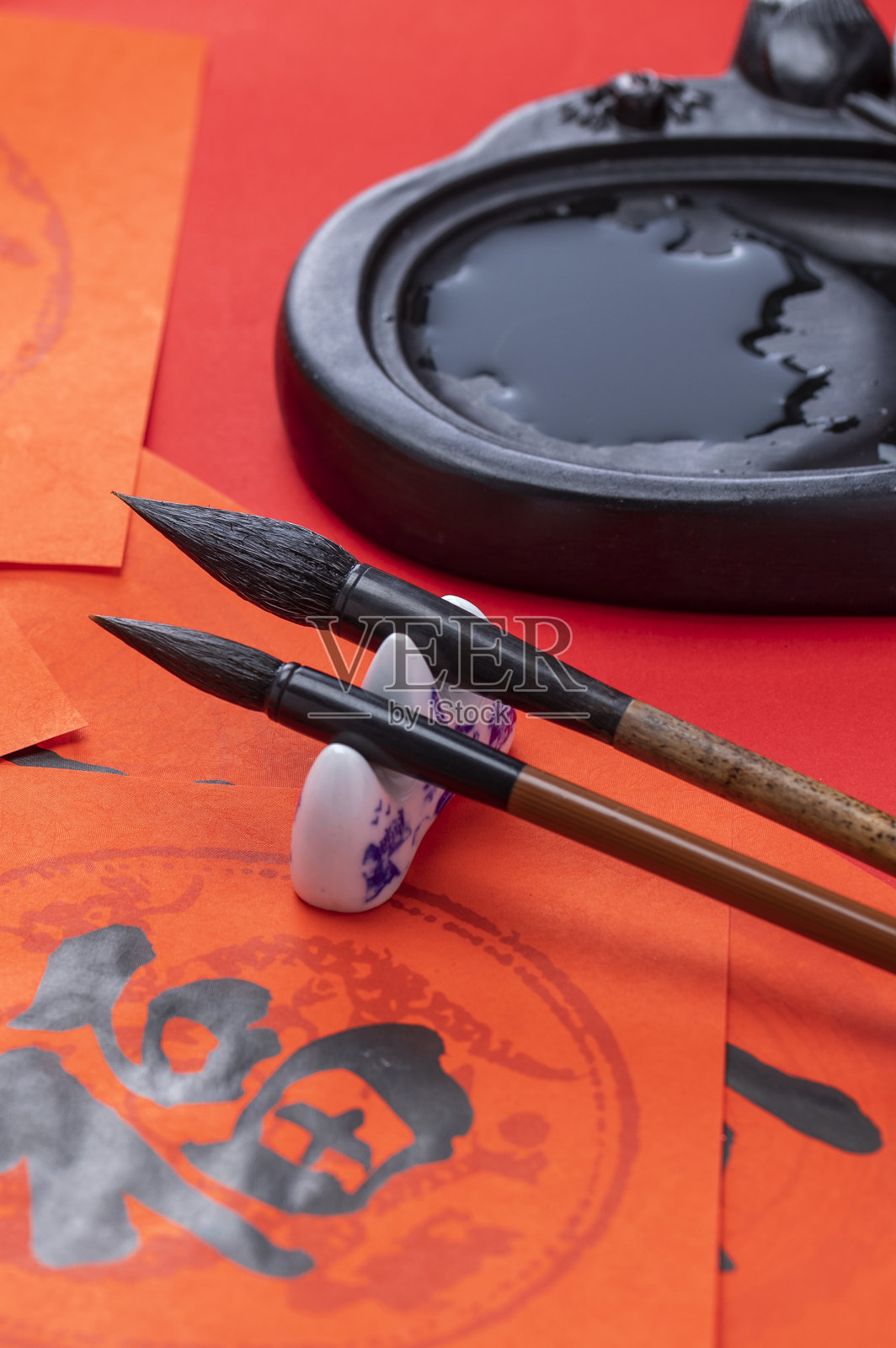毛笔和砚台放在写好的福字春联旁边照片摄影图片