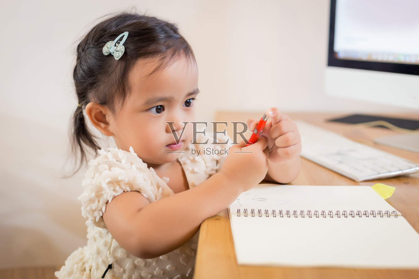可爱快乐的亚洲小女孩正在她的笔记本上写着什么。照片摄影图片