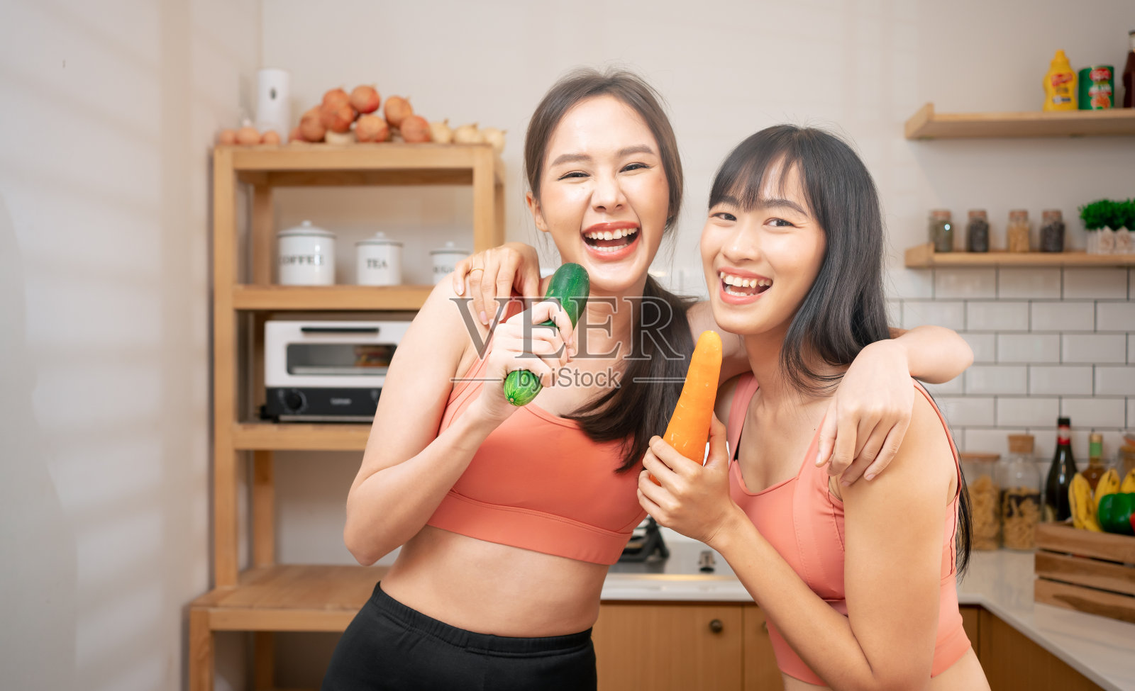 年轻的亚洲妇女微笑着拿着蔬菜和水果。泰国模特健身和瑜伽修身。运动穿的人在厨房吃各种有机食品。素食女性在家快乐照片摄影图片