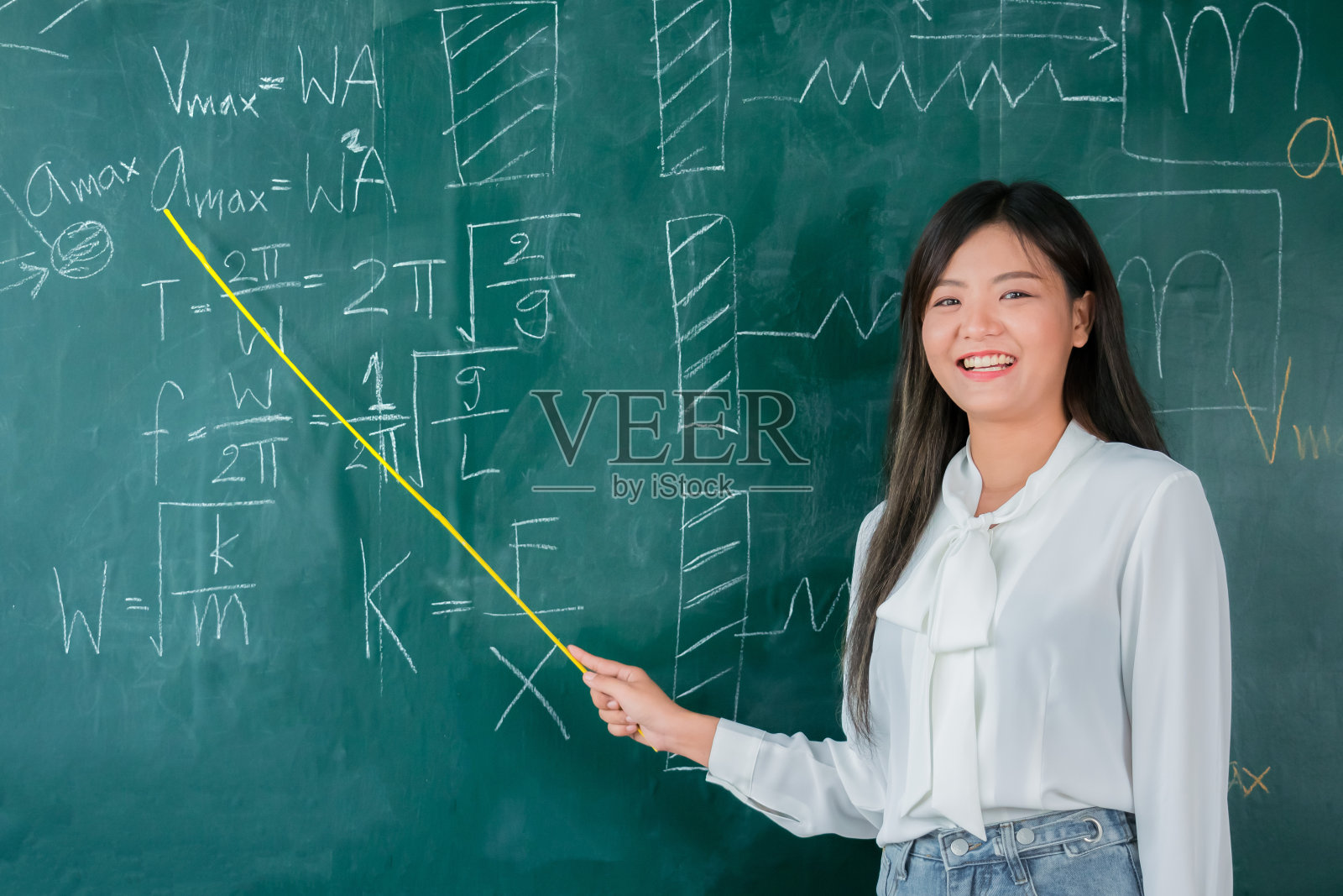 肖像迷人的微笑的亚洲女教师教学生在物理教室，女教师写在黑板上，高中和回学校的概念。照片摄影图片