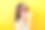 开朗的年轻韩国小姐舔着三勺不同口味的美味冰淇淋，站在黄色的背景上，戴着旅游眼镜素材图片