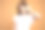 年轻的黑发女孩在白色t恤八卦与手靠近她的耳朵隔离在橙色背景素材图片